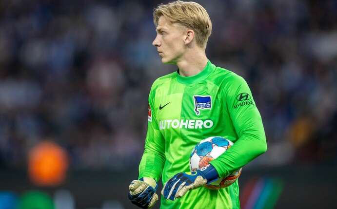 Herthas Torwart Oliver Christensen läuft mit einem Ball im Arm über das Spielfeld.