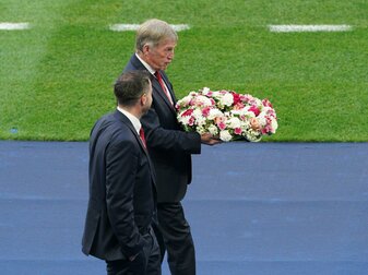 Liverpool-Legende Kenny Dalglish bringt den Kranz in Richtung eines hinter einem Tor angebrachten Vereinswappen der Reds. Liverpool-Legende Kenny Dalglish bringt den Kranz in Richtung eines hinter einem Tor angebrachten Vereinswappen der Reds.