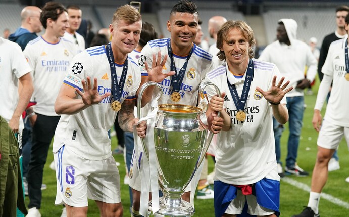 Toni Kroos (l), Carlos Casemiro (M) und Luka Modric von Real Madrid jubeln mit der Trophäe nach dem Sieg.