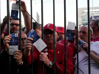 Liverpool-Fans zeigen ihre Eintrittskarten, während sie auf den Einlass ins Stade de France warten. Liverpool-Fans zeigen ihre Eintrittskarten, während sie auf den Einlass ins Stade de France warten.