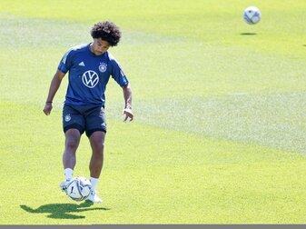 Serge Gnabry spielt auf dem Trainingsplatz in Herzogenaurach mit dem Ball.