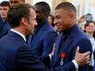 Frankreichs Präsident Emmanuel Macron (l) spricht bei einer Ehrung der Weltmeister von 2018 mit Kylian Mbappe.