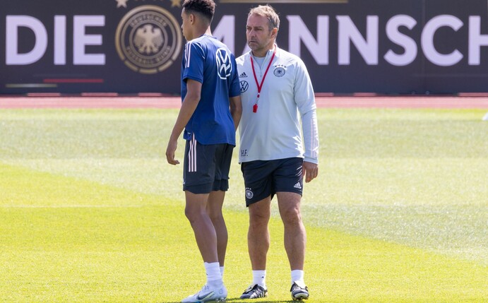 Bundestrainer Hansi Flick (r) spricht im Training mit Jamal Musiala.