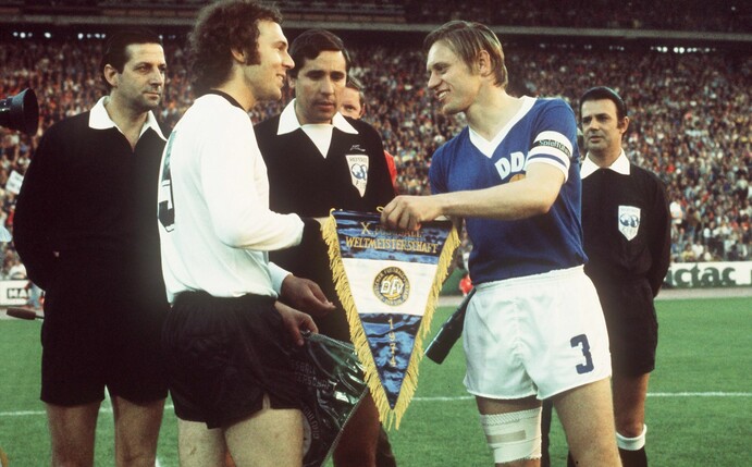 DDR-Auswahl-Kapitän Bernd Bransch (r) 1974 beim Wimpeltausch mit Franz Beckenbauer.