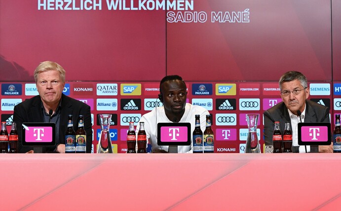 Sadio Mané (M) sitzt während seiner Vorstellung neben dem Vorstandsvorsitzenden Oliver Kahn (l) auf dem Podium.