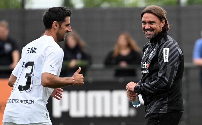 Gladbachs Lars Stindl (l) und Trainer Daniel Farke zeigten sich beim Trainingsauftakt in bester Laune.