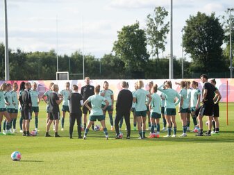 Spielerinnen und Bundestrainerin Martina Voss-Tecklenburg (l) sowie der Trainerstab stehen während einer Ansprache beieinander. Spielerinnen und Bundestrainerin Martina Voss-Tecklenburg (l) sowie der Trainerstab stehen während einer Ansprache beieinander.