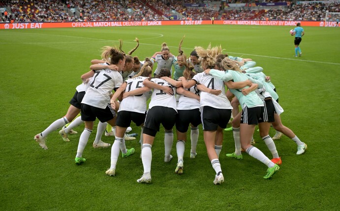 Deutschlands Fußball-Nationalspielerinnen feuern sich in einem Mannschaftskreis an. Mit wilder Entschlossenheit und kühlem Kopf sind sie mit einem 2:0 gegen Spanien ins EM-Viertelfinale gestürmt.