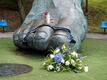 Blumen und Kerzen liegen an der überdimensionalen Bronzeskulptur vom rechten Fuß Seelers in Hamburg.