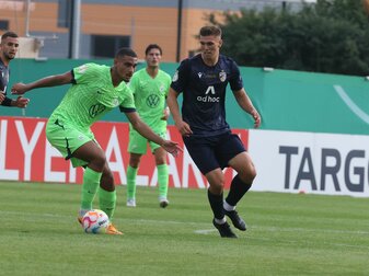 Wolfsburgs Maxence Lacroix (l) führt den Ball gegen Jenas Jan Dahlke eng am Fuß. Wolfsburgs Maxence Lacroix (l) führt den Ball gegen Jenas Jan Dahlke eng am Fuß.