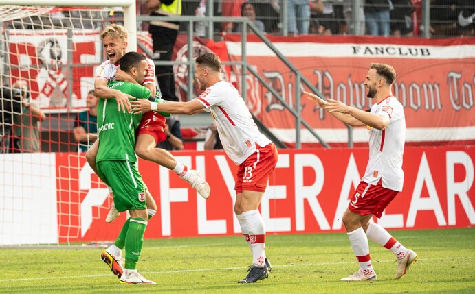 Regensburgs Dejan Stojanovic (l-r), Nicklas Shipnoski, Jan Elvedi und Benedikt Gimber feiern den Sieg im Elfmeterschießen.