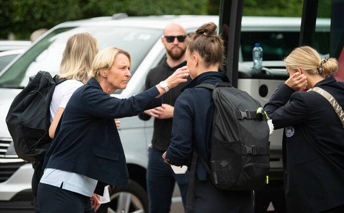 Bundestrainerin Martina Voss-Tecklenburg (l) versucht Spielerinnen bei der Abreise aufzumuntern.