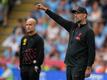 City-Trainer Pep Guardiola (l) und Liverpools Coach Jürgen Klopp stehen an der Seitenlinie.