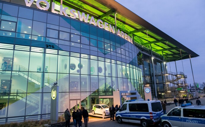 Polizeifahrzeuge stehen vor der Volkswagen Arena.