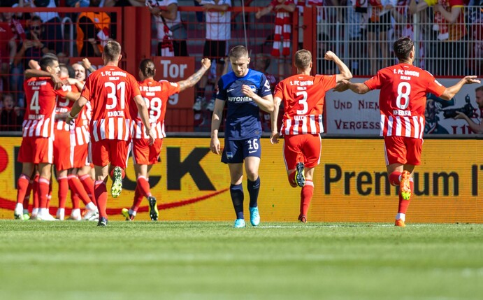 Die Mannschaft von Union jubelt nach dem 1:0 Treffer durch Sheraldo Becker - Herthas Jonjoe Kenny lässt den Kopf hängen.