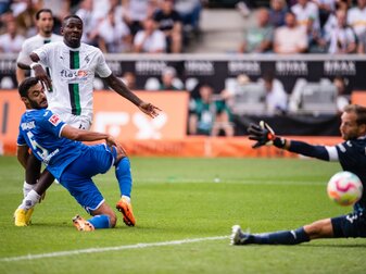 Gladbachs Marcus Thuram (M) trifft gegen Hoffenheims Ozan Kabak (l) und Torhüter Oliver Baumann zum 2:1. Gladbachs Marcus Thuram (M) trifft gegen Hoffenheims Ozan Kabak (l) und Torhüter Oliver Baumann zum 2:1.