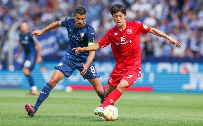 Bochums Anthony Losilla (l) kämpft mit dem Mainzer Jae-Sung Lee um den Ball.