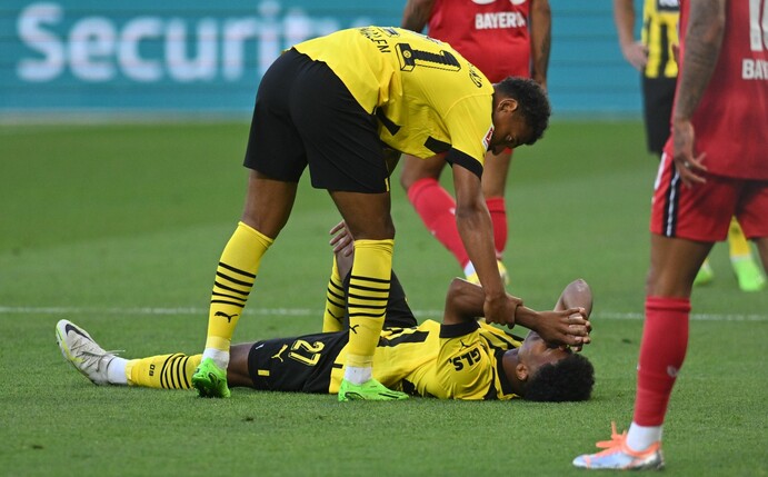Dortmund-Neuzugang Karim Adeyemi liegt verletzt auf dem Rasen.
