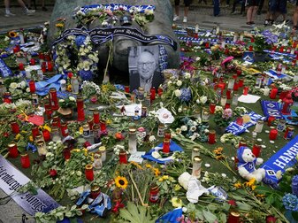 Ein Foto von Uwe Seeler und Blumen, Fan-Schals und Trauerlichter stehen an der Bronzeplastik vor dem Volksparkstadion. Ein Foto von Uwe Seeler und Blumen, Fan-Schals und Trauerlichter stehen an der Bronzeplastik vor dem Volksparkstadion.