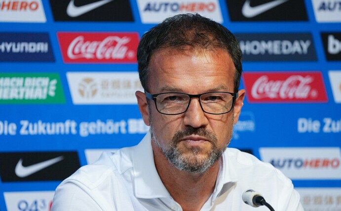 Herthas Geschäftsführer Sport, Fredi Bobic, sitzt während einer Pressekonferenz auf dem Podium.